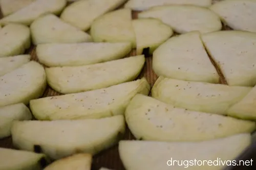 Sliced eggplant round halves on a sheet pan.