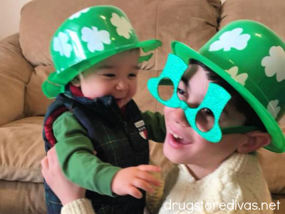 Two boys wearing St Patrick's Day hats and glasses.