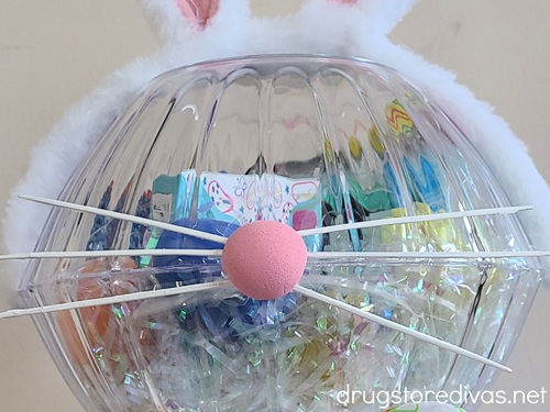 A bunny face made with white zip ties and a pink foam nose on a bowl filled with Easter candy.