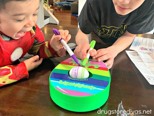 Two boys using the Eggmazing egg decorator.