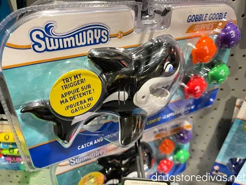 A package with a plastic shark and fish pool toy in it called the Gobble Gobble Guppies.