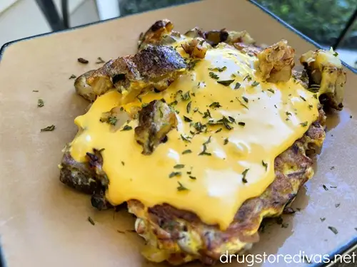 Potato and ham hash on a brown plate.