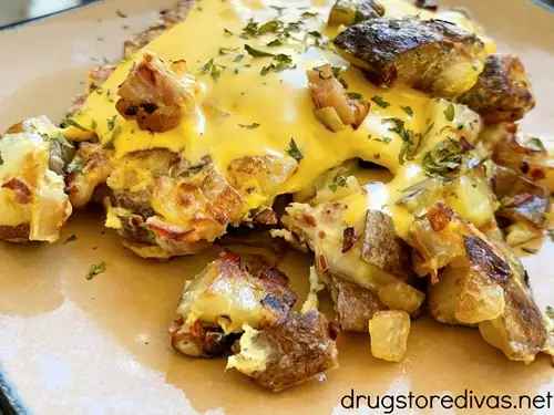 Potato and ham hash on a brown plate.