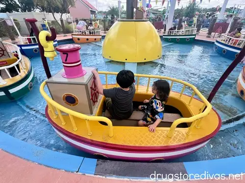 Two boys riding on a boat at the Peppa Pig Theme Park in Florida.