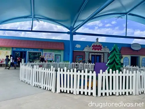 A white picket fence in front of a ride at Peppa Pig Theme Park in Winter Haven, Florida.