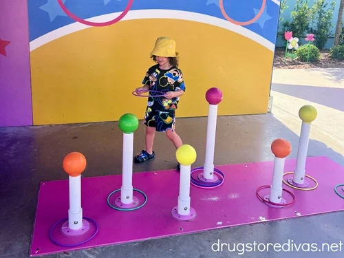 A young boy playing a life-sized ring toss game at Peppa Pig Theme Park in Winter Haven, Florida.