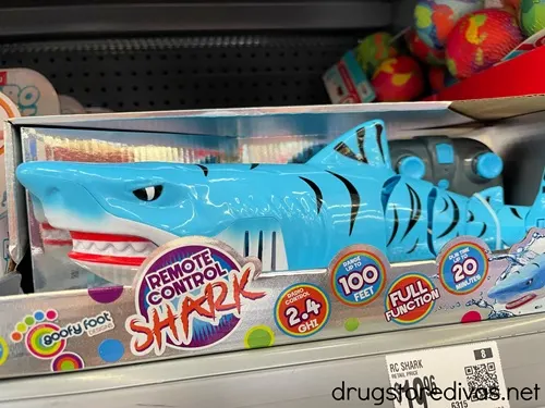 A box with a remote control shark in it on a shelf in the store.