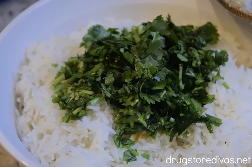 Chopped cilantro on top of cooked rice.