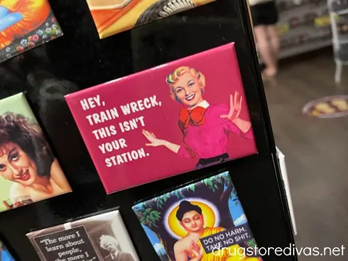 A pink magnet with a woman on it that says Hey, train wreck this isn't your station.