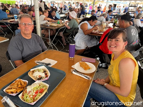 A man an a woman sitting at a table with food at the Wilmington Greek Festival.