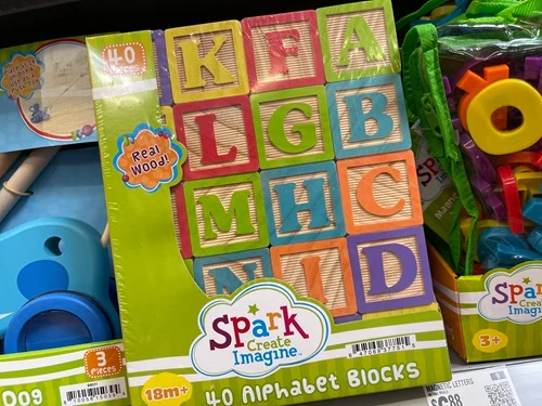 A wooden ABC/123 block set in its package on a shelf in the store.