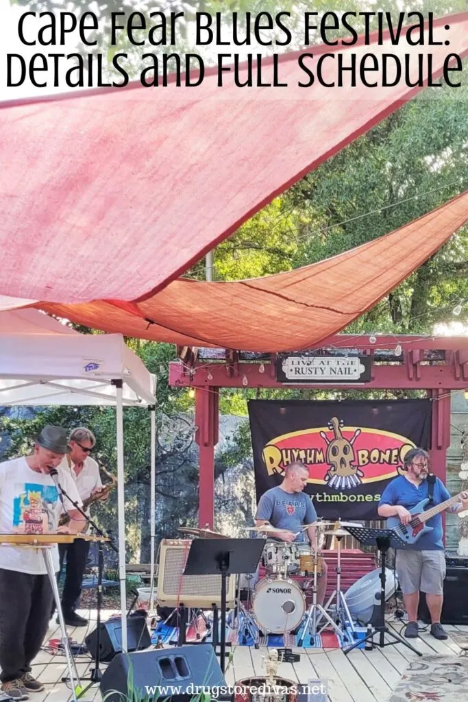 A band playing under a red sail with the words "Cape Fear Blues Festival: Details and Full Schedule" digitally written above them.