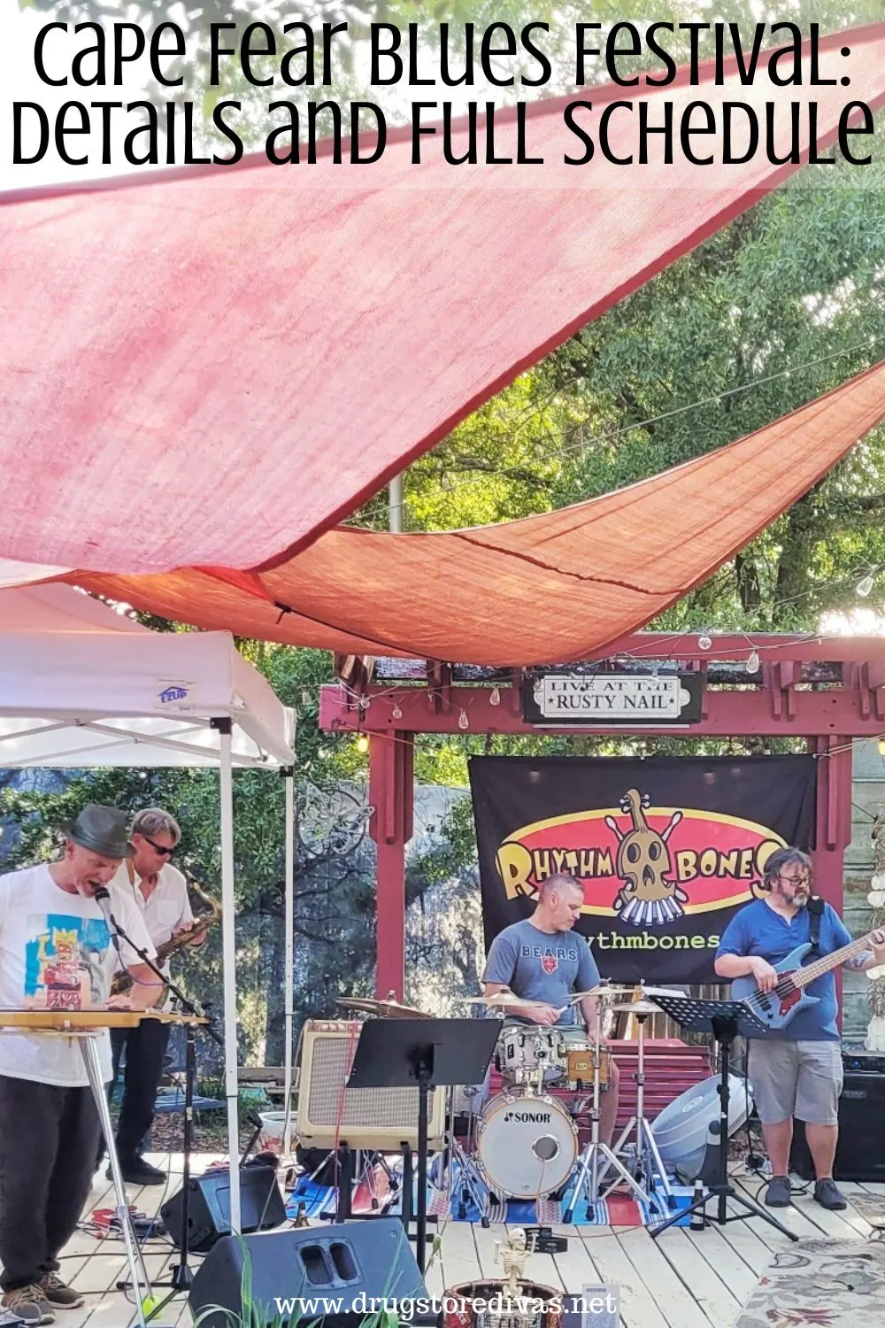 A band playing under a red sail with the words 