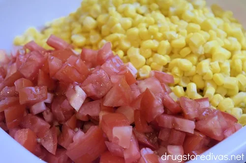 Chopped tomato and corn in a white bowl.