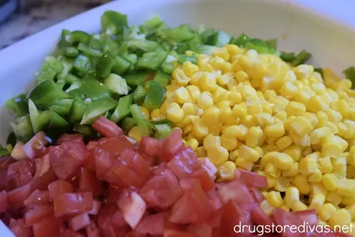 Chopped tomato, corn, and green pepper in a white bowl.