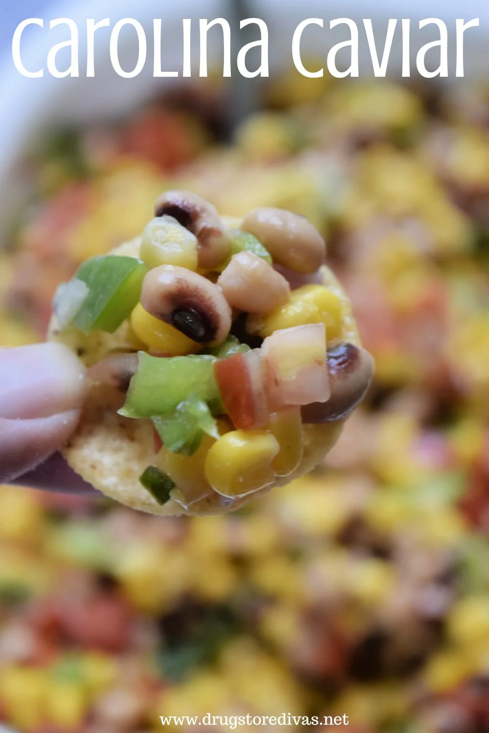 Fingers holding a chip with black-eyed peas, green pepper, corn, and red onion on it over a bowl of the same with the words 