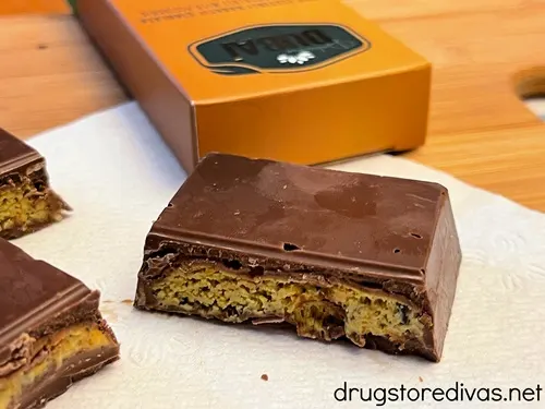 Pieces of Dubai chocolate on a napkin with a gold box behind them.