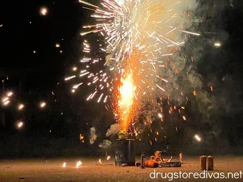 Fireworks being lit in a street in a neighborhood.