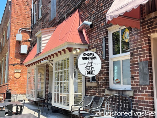 The outside of a brick building with a sign that says Gnome Nom Nom in downtown Wilmington, NC.