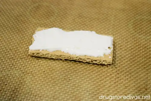 A graham cracker piece with Marshmallow Fluff smeared on top.