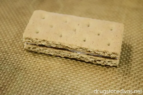 Two graham cracker pieces on top of each other on a silicone baking mat.