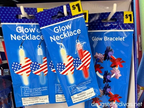 Three packs of patriotic glow necklaces and bracelets on pegs at a store.