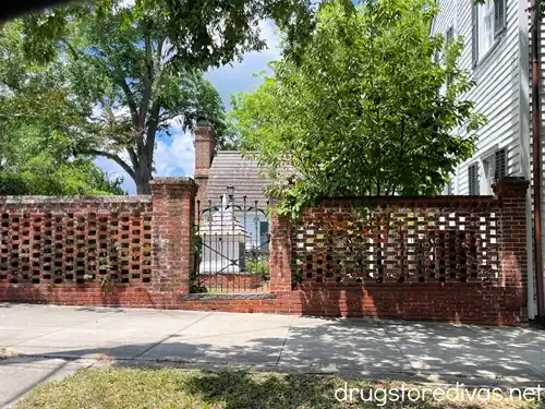 A brick wall with a gate entrance leading to the St James Parish Cemetery in downtown Wilmington, NC.