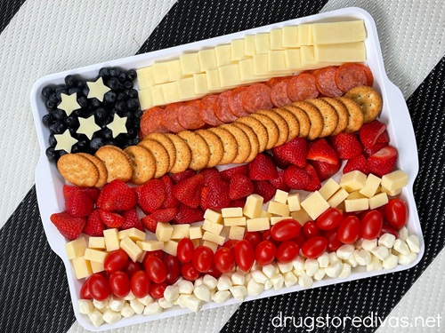 Meat, cheese, and fruit arranged on a white tray to look like an American flag.