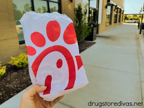 A hand holding a Chick-fil-A bag.