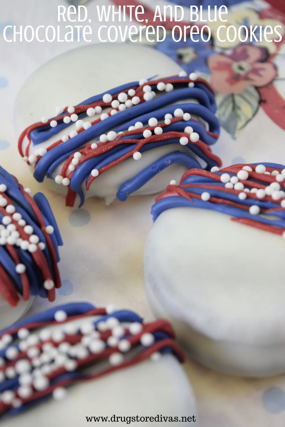 Four white Oreo cookies with blue and white lines and white nonpareil sprinkles on them on a white napkin with the words 