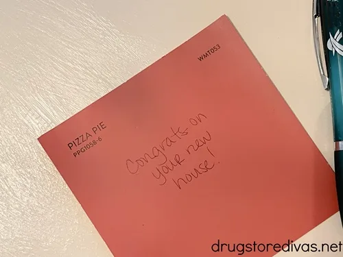 A salmon colored square that says "Congrats on your new home!" written on it.