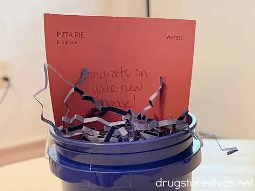 A salmon colored paper stuck into a blue mini bucket.