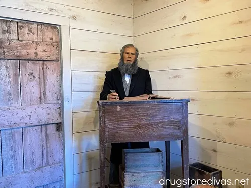 An animatronic man behind a wooden desk at the Elloree Heritage Museum.