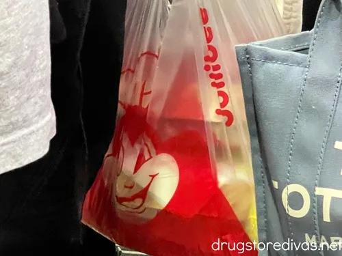 A plastic bag from Jollibee filled with to go food containers.