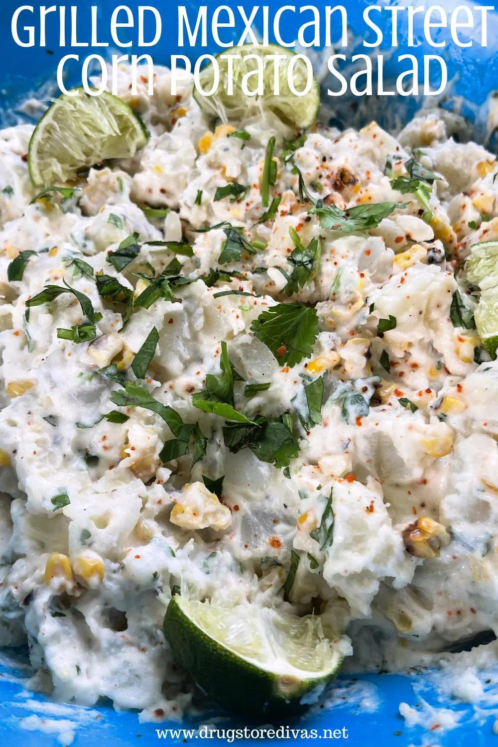 Potato salad with corn, cilantro, and lime wedges in a blue bowl with the words 