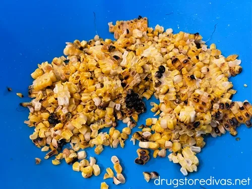Grilled corn kernels in a blue bowl.
