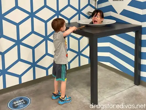 An optical illusion where a woman's bodyless head is on a platter and a young boy is trying to feed her with a spoon at the Museum of Illusions in Washington ,DC.