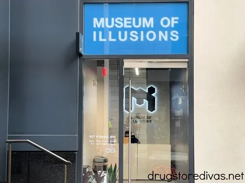 An entrance door for the Museum of Illusions with a blue sign with the words Museum of Illusions written on top.