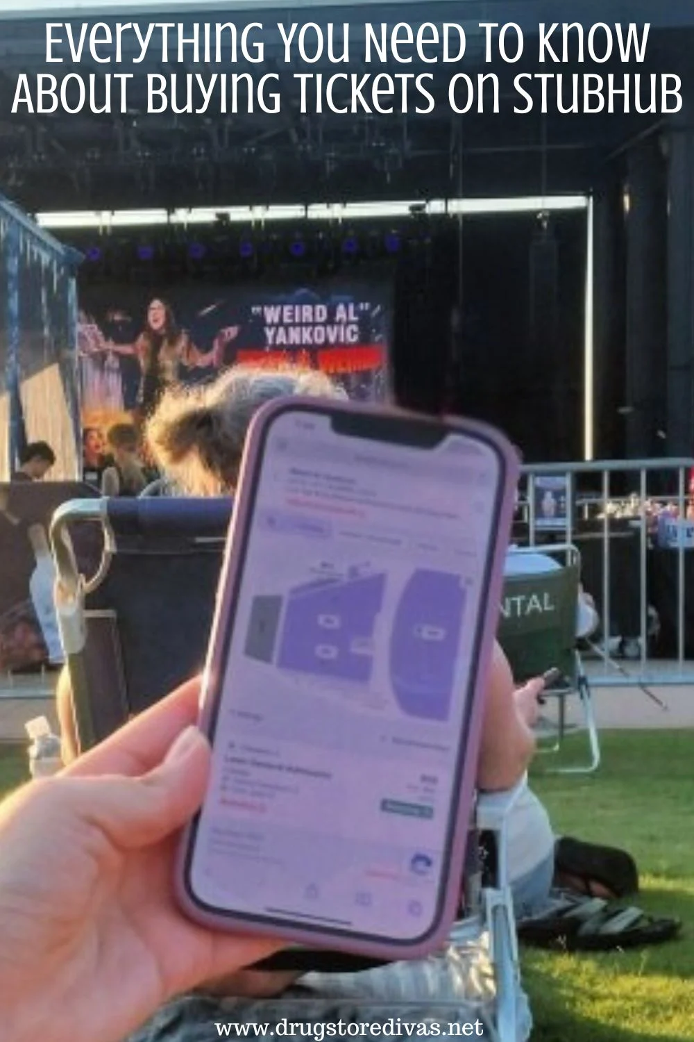 A hand holding a phone open to the Stubhub website, in front of a music stage, with the words 