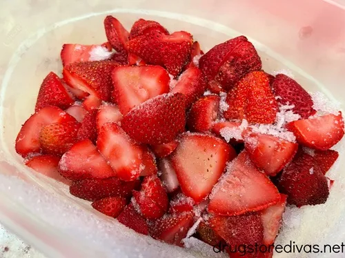 Frozen strawberry halves in a clear container.