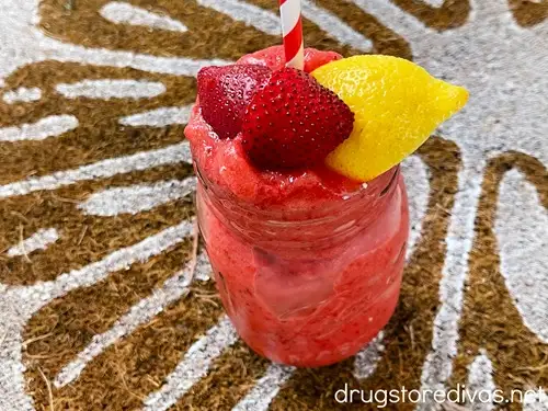 A frozen strawberry lemonade drink with frozen fruit on top.