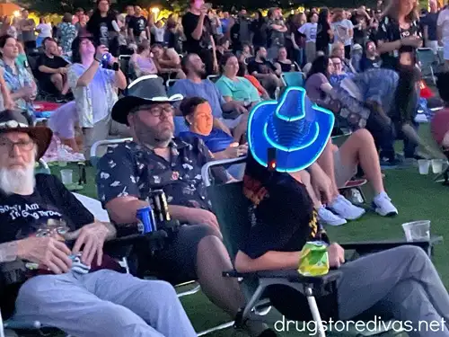 A man wearing a cowboy hat that's glowing from glow sticks.