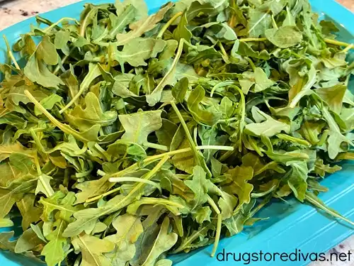 Arugula on a blue tray.