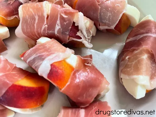 A tray of prosciutto wrapped peach and mozzarella slices.
