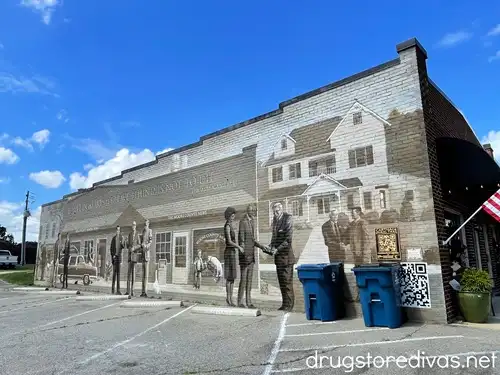 A brown and gray mural of two buildings called Landmarks and Legacies.