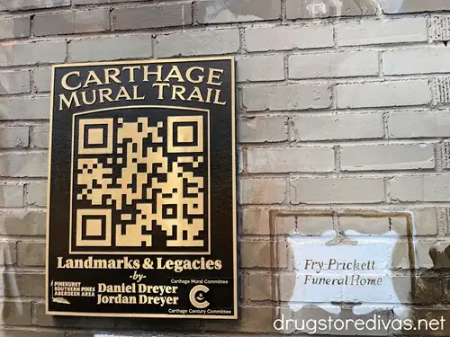 A metal QR code for the Carthage Digital Mural Trail on a wall.
