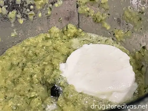 Greek yogurt on top of a blended green soup.