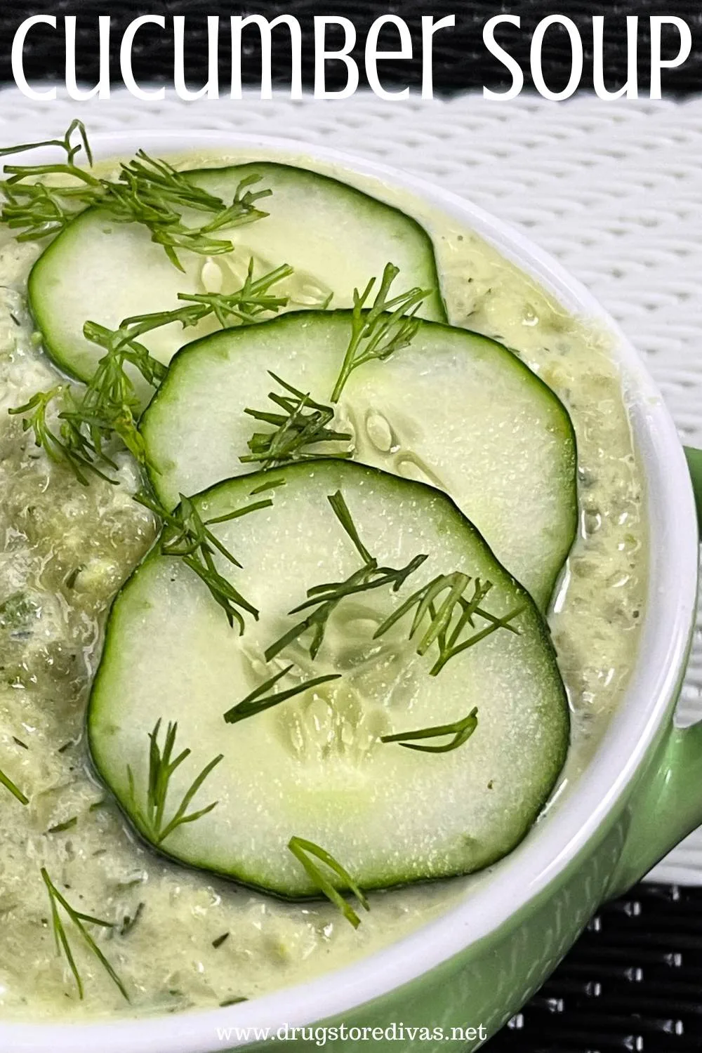 A green bowl with a white rim filled with a green soup with cucumber slices and dill on top and the words 