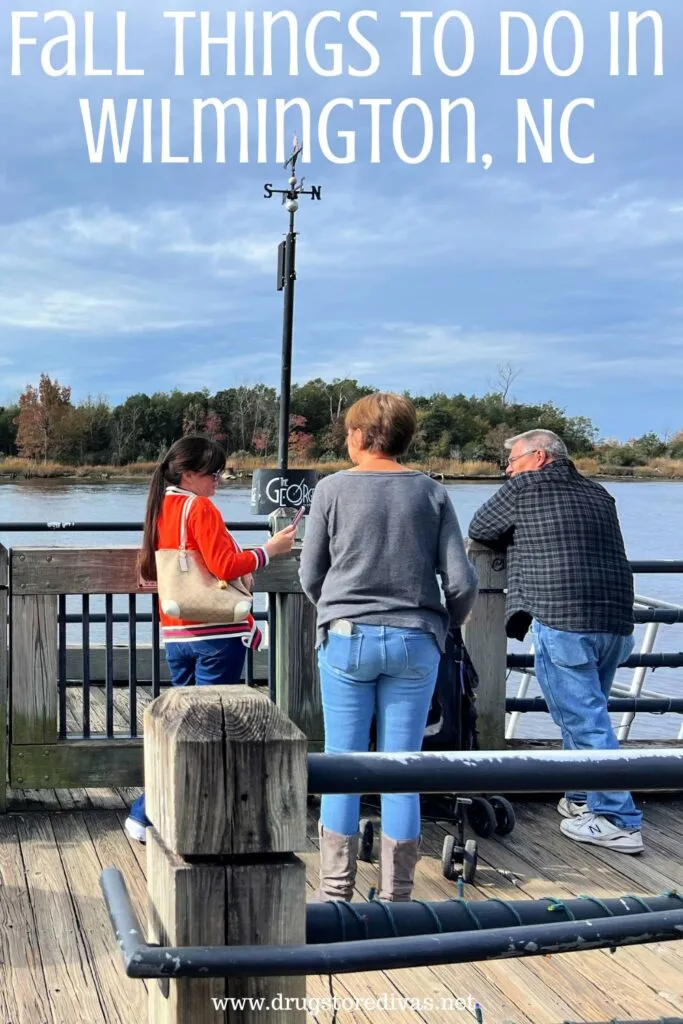 Three people, two women and a man, on the boardwalk in downtown Wilmington with the words "Fall Things To Do In Wilmington, NC" digitally written on top.