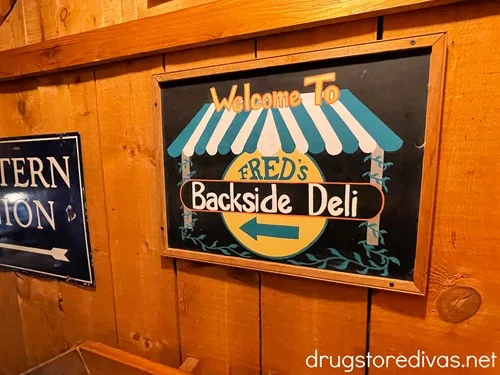 A sign on a wooden wall advertising Fred's Backside Deli at Fred's General Mercantile in Beech Mountain, NC.